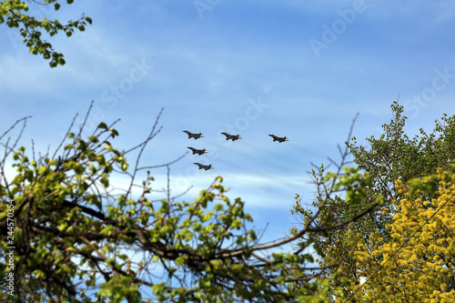 Combat aircraft fighters fly against the blue sky. Jet squadron