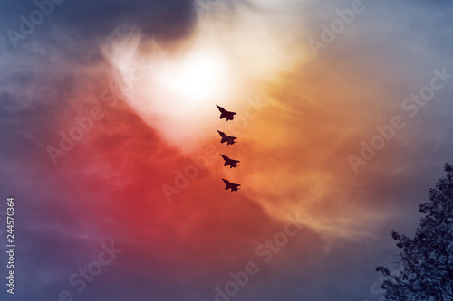 Wallpaper Mural Combat aircraft fighters fly against the red fire sky. Jet squadron Torontodigital.ca