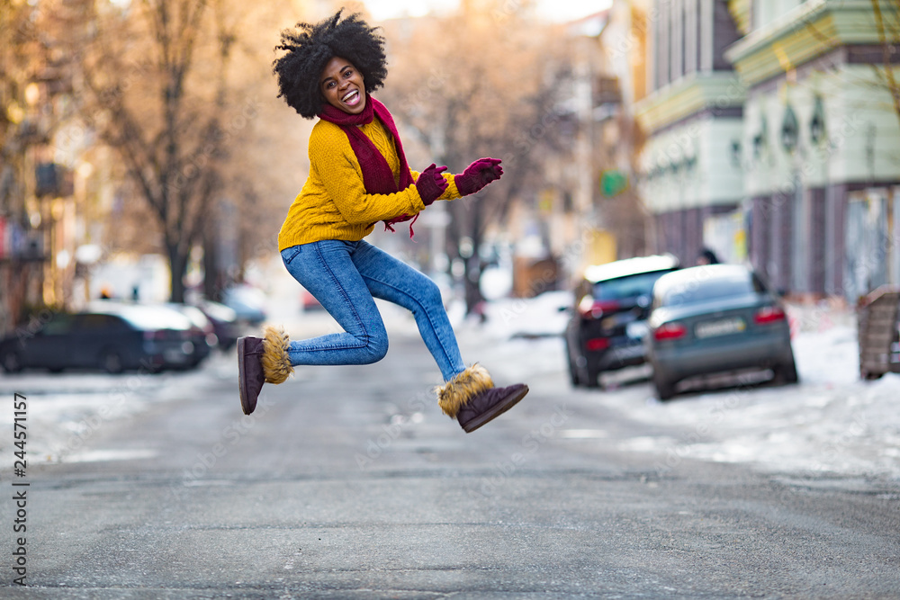 Young black woman is jumping in the middle of the street. Young black woman is jumping in the middle of the street.