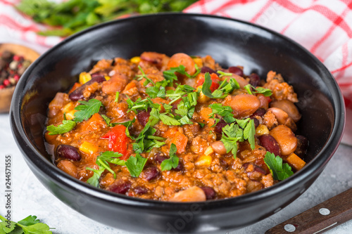 Chili con carne from meat and vegetables on stone table close up.
