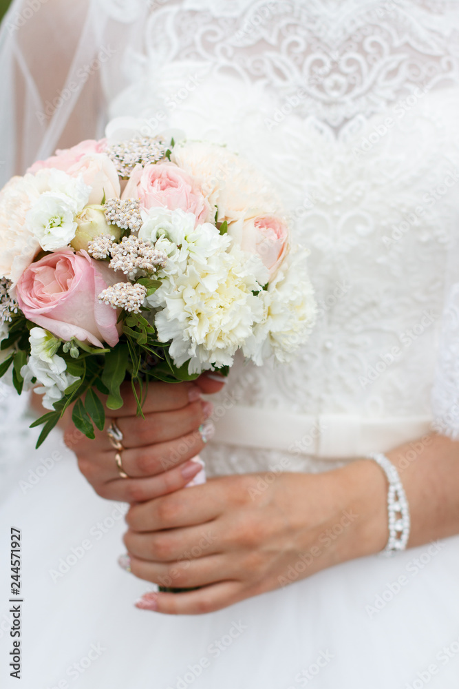 bridal bouquet of roses in beeches on the background of a wedding dress bridal bouquet of roses in beeches on the background of a wedding dress