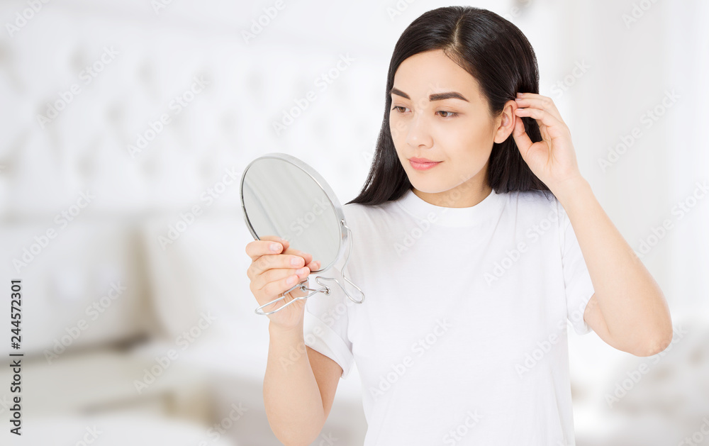 Asian woman looking in mirror at home. Macro japanese female face isolated on white background. Skin care and beauty spa concept. Anti aging and collagen. Copy space Asian woman looking in mirror at home. Macro japanese female face isolated on white background. Skin care and beauty spa concept. Anti aging and collagen. Copy space