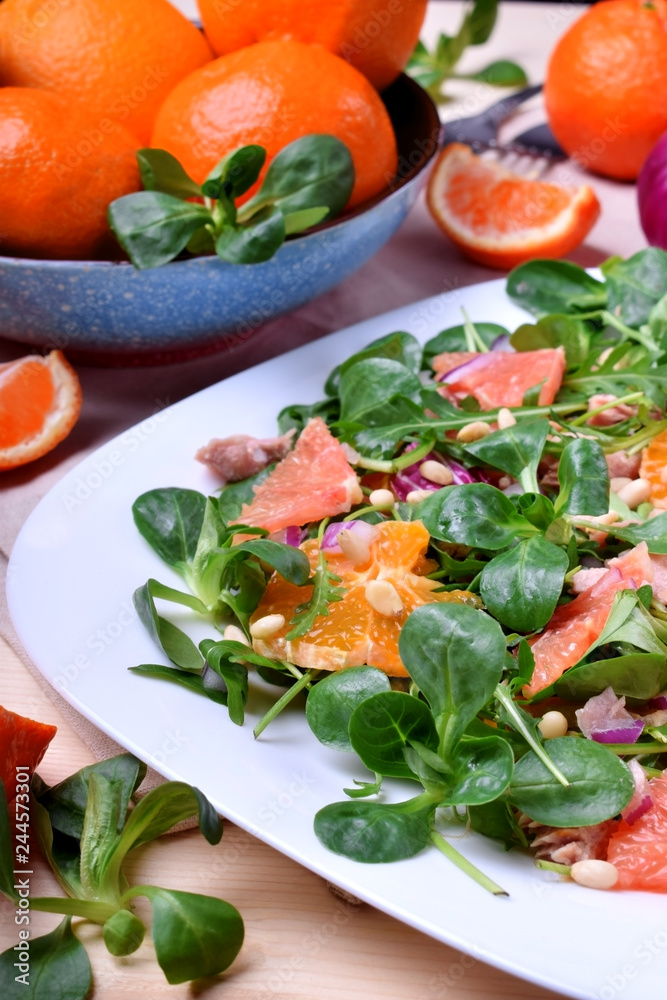 Salad with radicchio, mandarins, red oranges and canned tuna on a white plate Salad with radicchio, mandarins, red oranges and canned tuna on a white plate