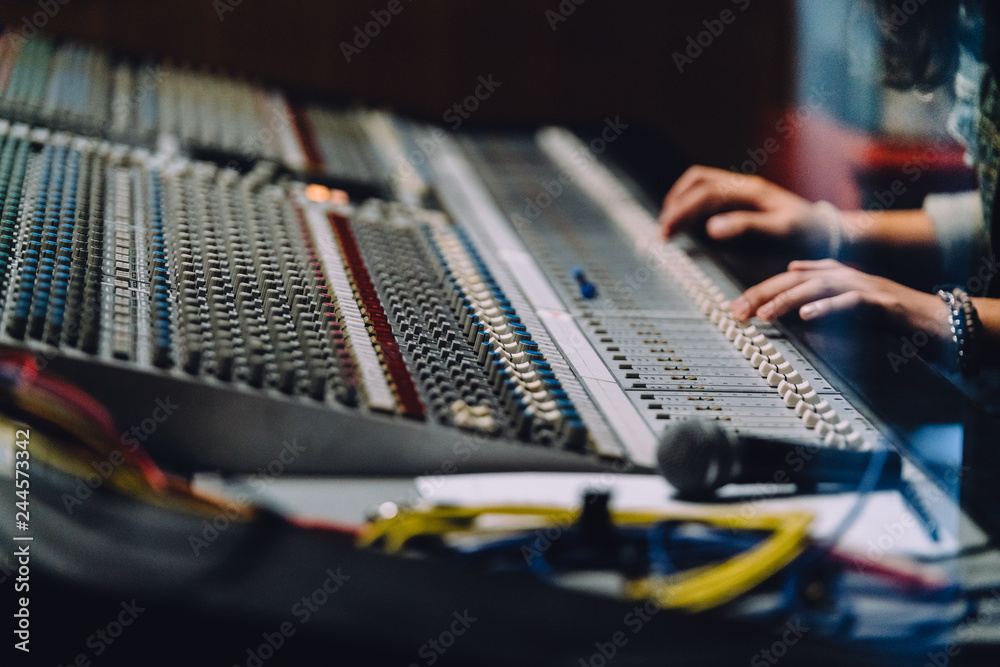 Professional right hand nearby soundboard are mixing sounds by audio