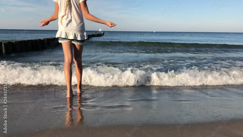 Kind läuft am Strand und betrachtet dann das Meer 