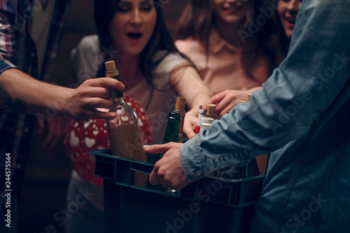 Man holding box with bottles of champagne at a party