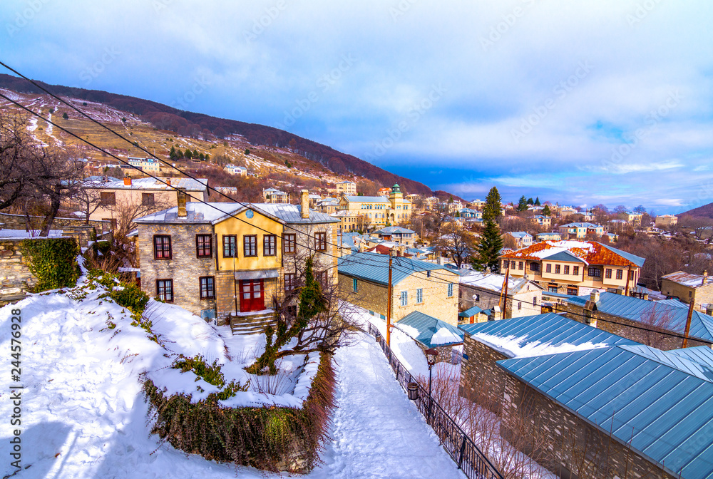 View of traditional stone buildings and streets with snow at the famous village of Nymfaio near Florina, Greece. 