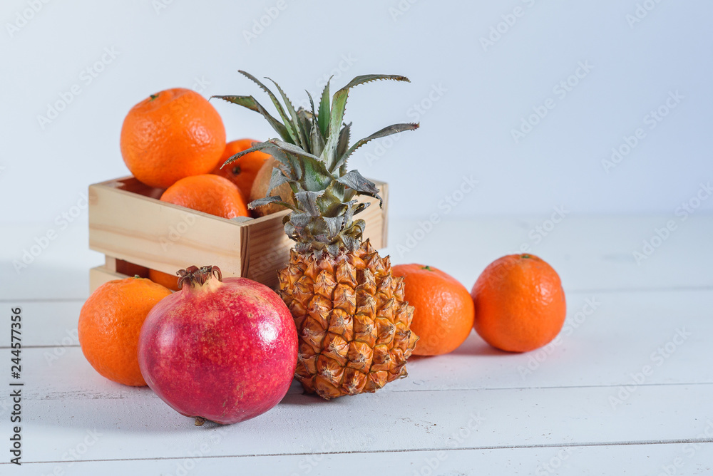Group of fresh tropical fruits in small wooden box.