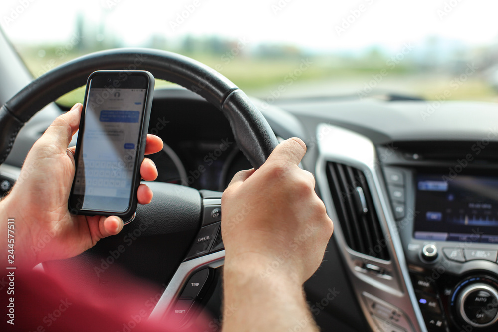 Man checking his text messages while driving. Dangerous texting in car concept. Man checking his text messages while driving. Dangerous texting in car concept.