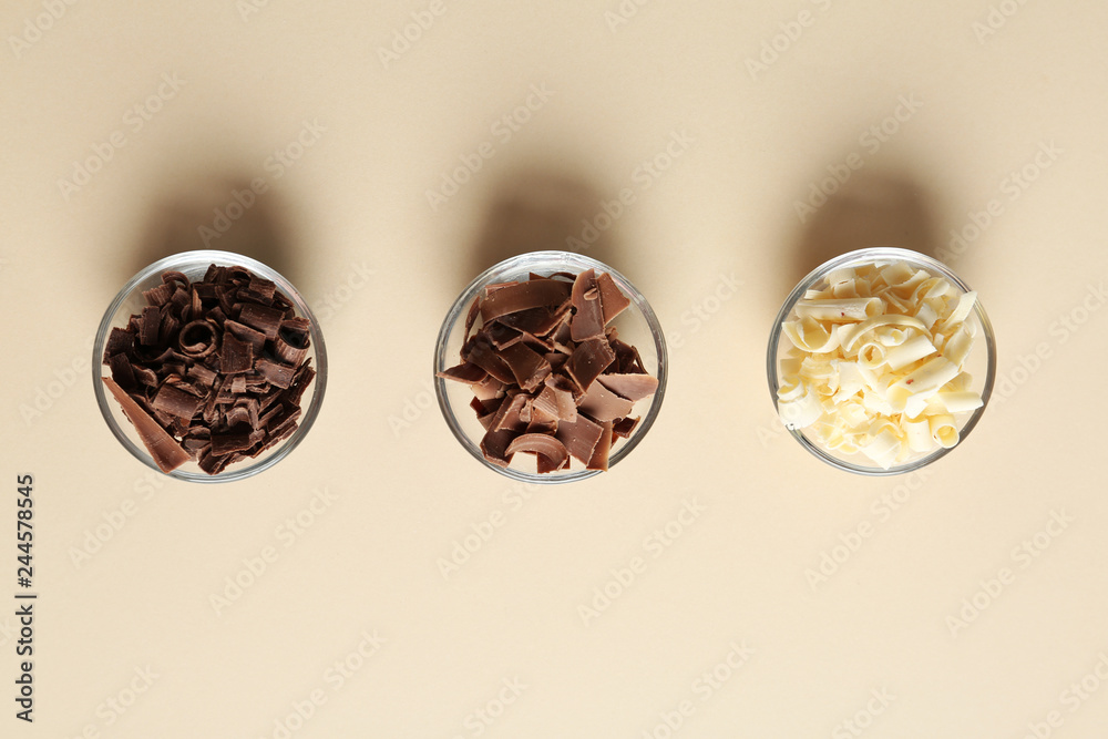 Bowls with different chocolate curls on color background, top view Bowls with different chocolate curls on color background, top view