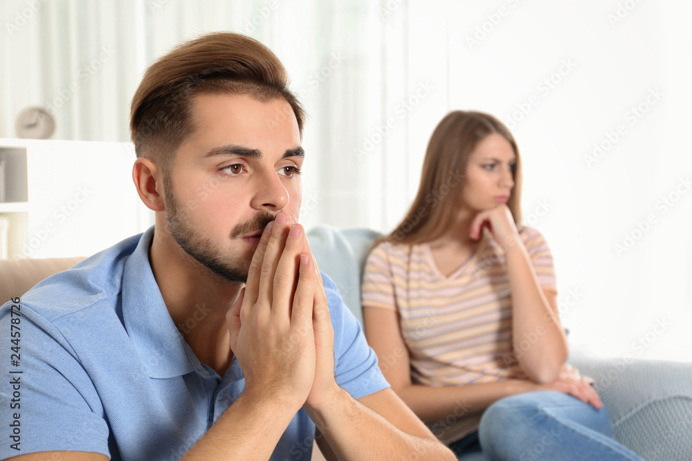 Young couple with relationship problems in living room Young couple with relationship problems in living room