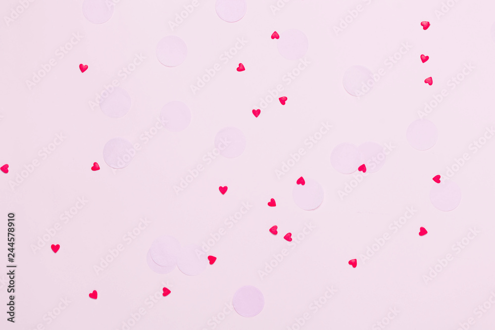 Valentine's day background. Little red hearts on pink background with shining lights bokeh.