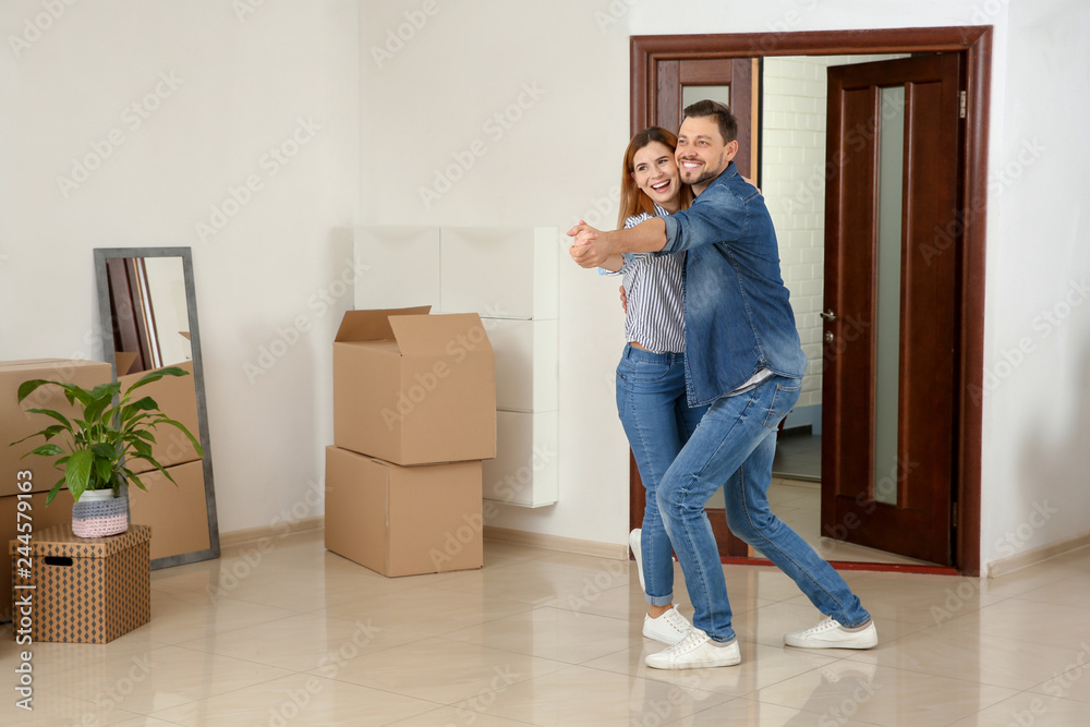 Couple dancing near moving boxes in their new house - obrazy, fototapety, plakaty 