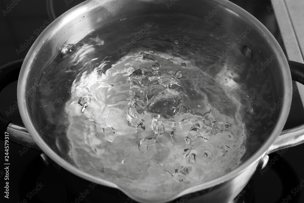 Pot with boiling water on stove, closeup Pot with boiling water on stove, closeup