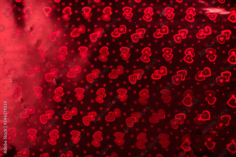 Hologram with hearts, the background on Valentine's Day or a wedding. Background with a pattern in hearts on wrapping paper.
