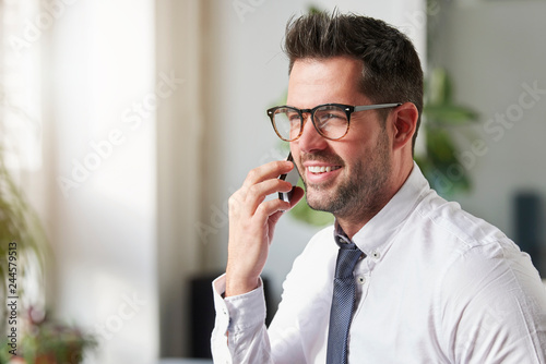 Businessman making a call while sitting in the office