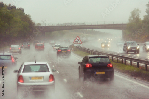 Traffics on a rainy wet highway in fog water spray #244579716