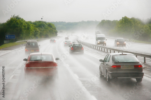 Traffics on a rainy wet highway in fog water spray #244579741
