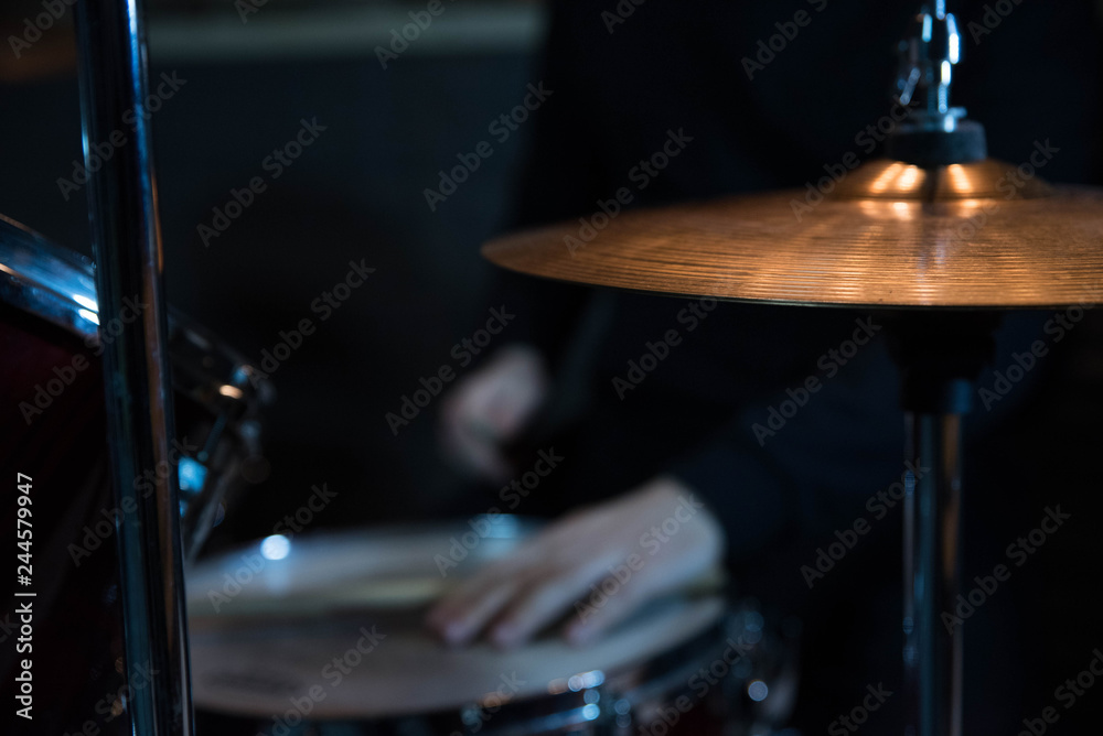 Fototapeta premium Professional drum set closeup. Drummer with drumsticks playing drums and cymbals, on the live music rock concert or in recording studio 