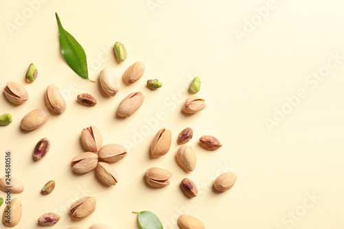 Composition with organic pistachio nuts on color background, flat lay. Space for text
