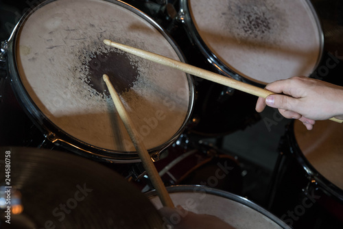 Professional drum set closeup. Drummer with drumsticks playing drums and cymbals, on the live music rock concert or in recording studio 