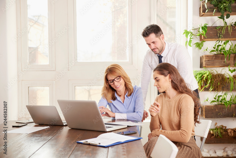 Teamwork in the office. Group of business people working together on laptop in the office Teamwork in the office. Group of business people working together on laptop in the office