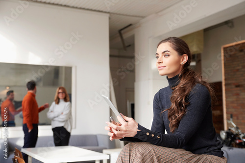Businesswoman using her digital tablet while sitting in the office and working