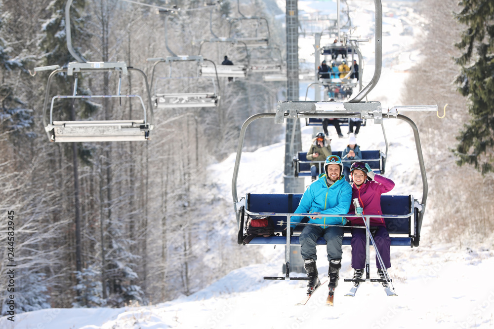 Obraz premium People using chairlift at mountain ski resort. Winter vacation