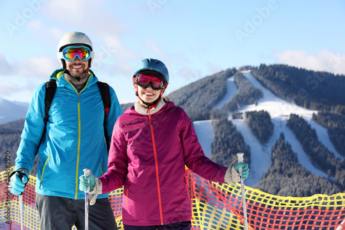 Couple spending winter vacation at mountain ski resort. Space for text