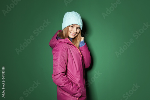Young woman wearing warm clothes on color background. Ready for winter vacation © New Africa