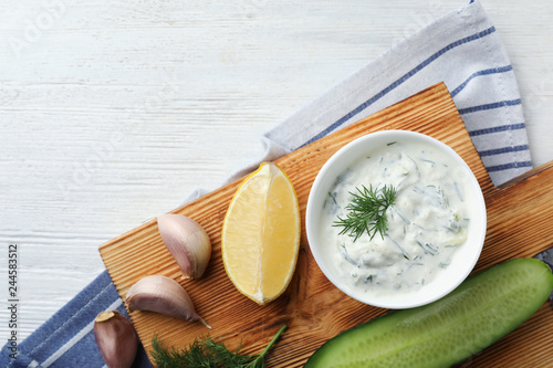 Cuadro en lienzo Tzatziki cucumber sauce and ingredients on wooden background, top view
