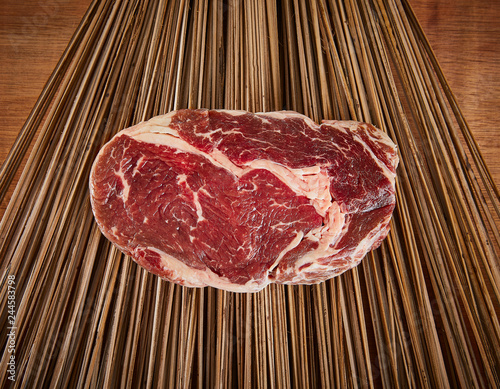 Raw Ribeye Steak on a wood backdrop 