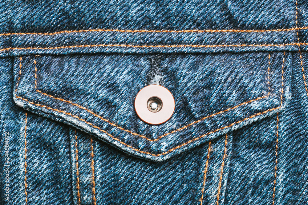 Blue jeans fabric pocket with metal button. Grunge used fashion jacket background. Blue jeans fabric pocket with metal button. Grunge used fashion jacket background.