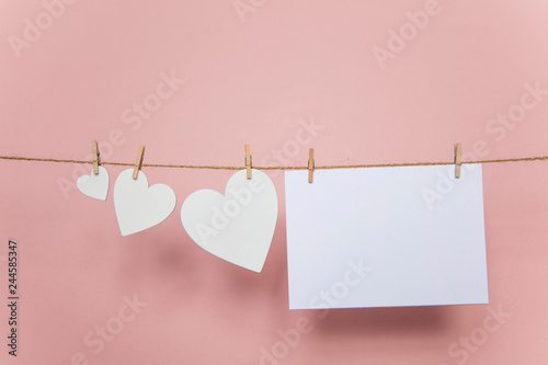 Blank love letter pegged to a line with white hearts. Valentine's day, mother's day.