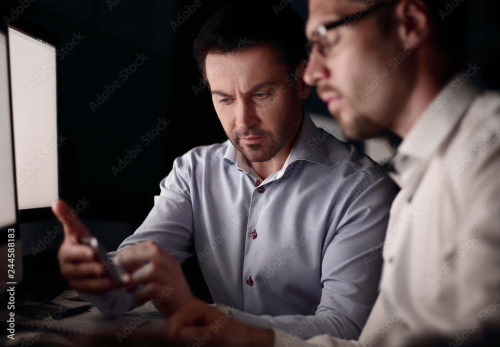 close up.two business men in the workplace in the evening close up.two business men in the workplace in the evening