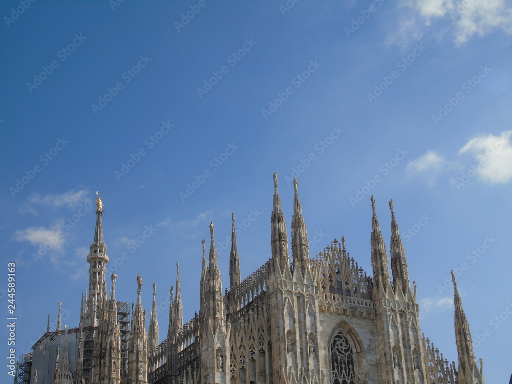 Milan, Italy - 02/14/2018: Amazing photography to the Duomo of Milano in winter days with some people, a great blue sky and some details of the exterior part of the structure