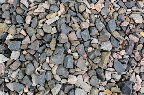 Grey stone chippings lying on the ground outdoors. Natural background texture.