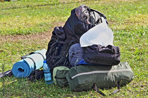 Duffel bags on the green grass on a summer day - summer sports tourism, travel, camping, scouting