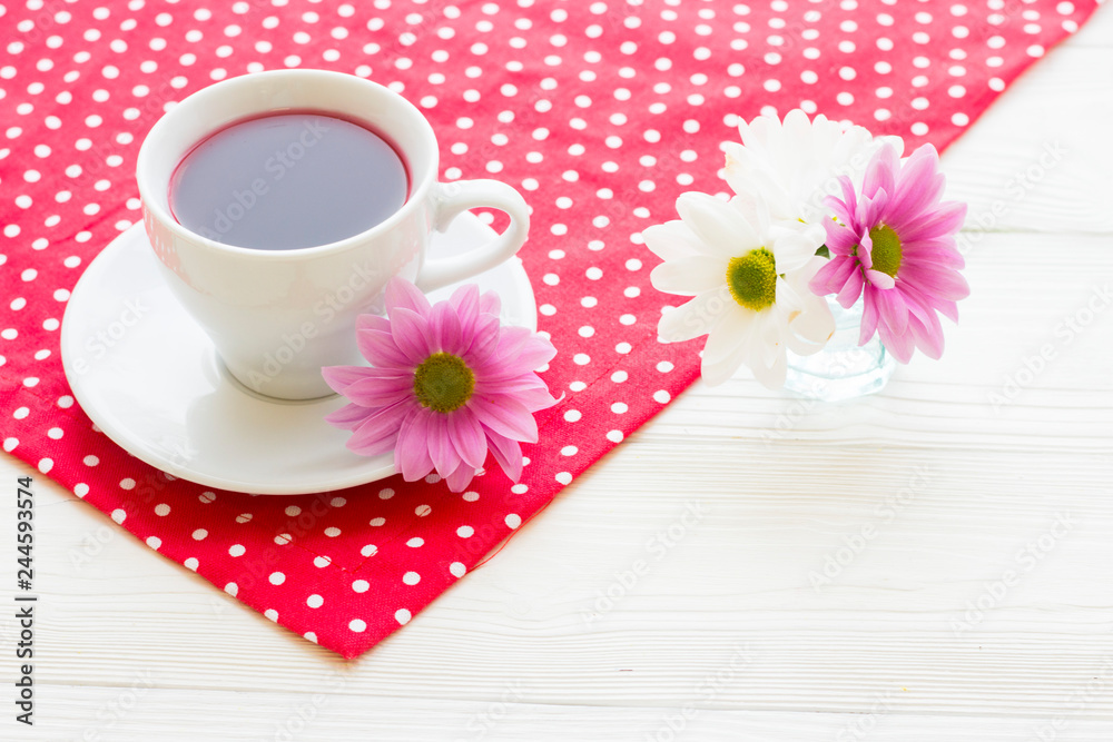Black tea ceremony - a cup of tea, teapot, sugar, cakes, flowers on a red with white dots background Black tea ceremony - a cup of tea, teapot, sugar, cakes, flowers on a red with white dots background