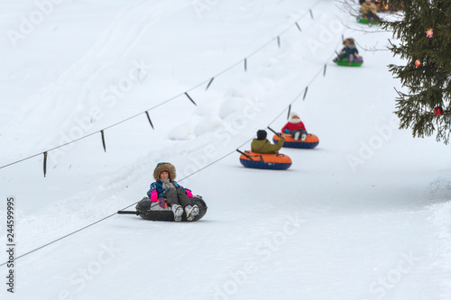 Girl riding snow tube winter day photo