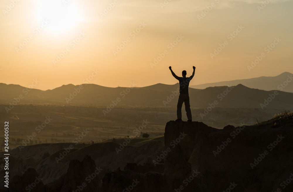 Man's silhouette on mountain peak