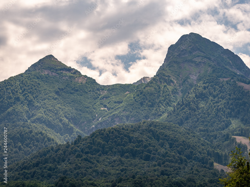 View of green mountains with cable car and peaks