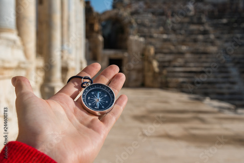 Man holding compass in ancient city