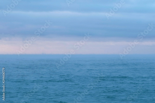 Beautiful seascape with pink sunset and blue clouds. Calm sea.