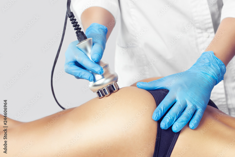 The doctor does the Rf lifting procedure on the legs, buttocks and hips of a woman in a beauty parlor. Treatment of overweight and flabby skin. The doctor does the Rf lifting procedure on the legs, buttocks and hips of a woman in a beauty parlor. Treatment of overweight and flabby skin.