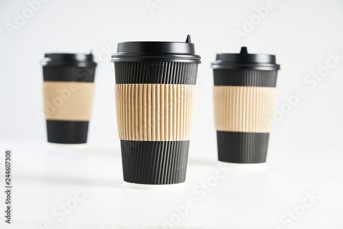 Three paper disposable coffee black cup for take away or to go, isolated on white, space for design layout.