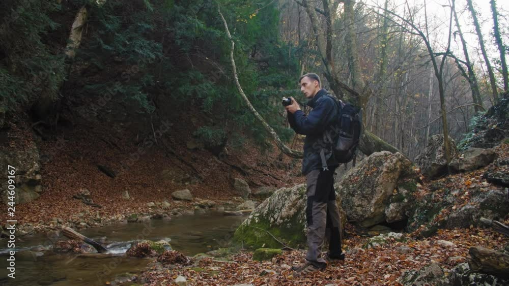 Young photographer photographing in mountain valley in 4k Young photographer photographing in mountain valley in 4k