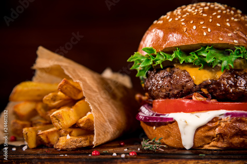 Tasty burger on wooden table. Fototapet