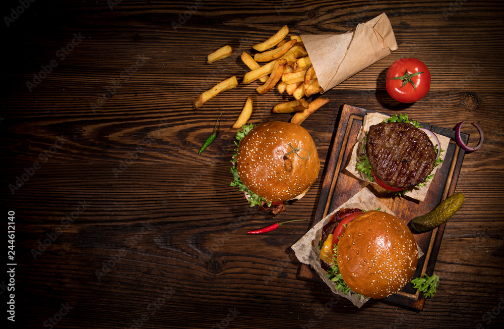 Top view of tasty burgers on wooden table.