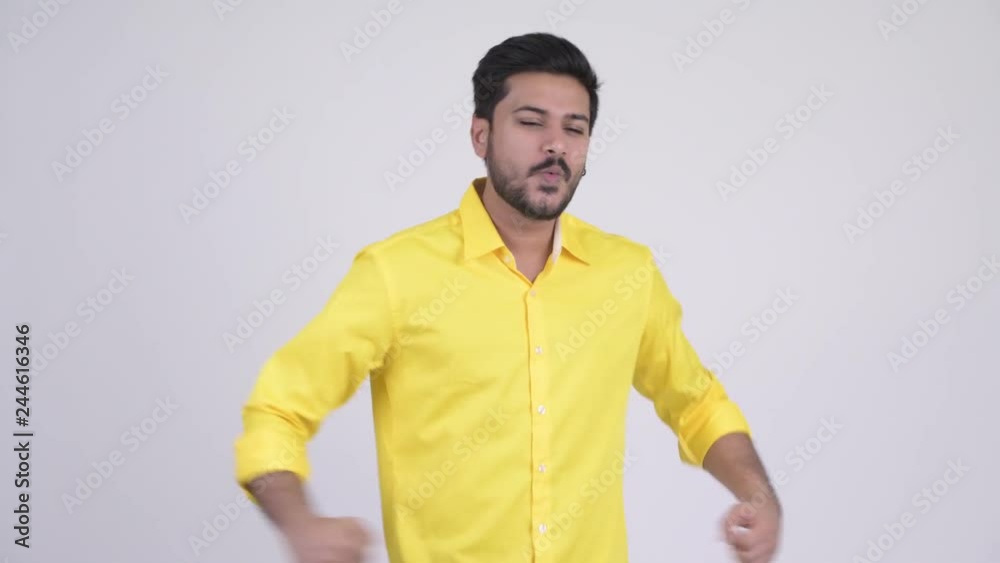 Young happy bearded Indian businessman getting good news Young happy bearded Indian businessman getting good news